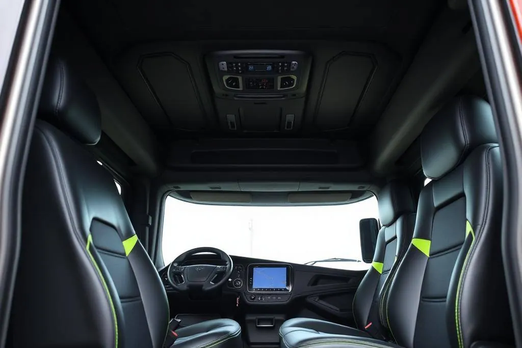 Modern semi truck cab interior with digital dashboard and lime green accents